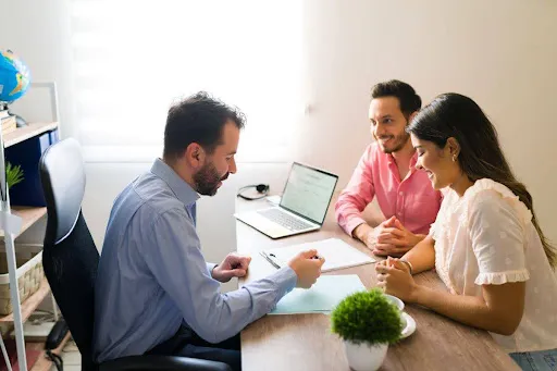 Couple consulting with a financial advisor in a modern office setting.