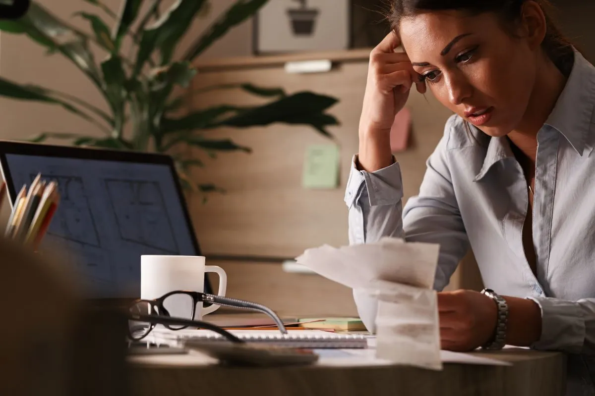 businesswoman feeling worried about financial debts analyzing bills while working office (1)