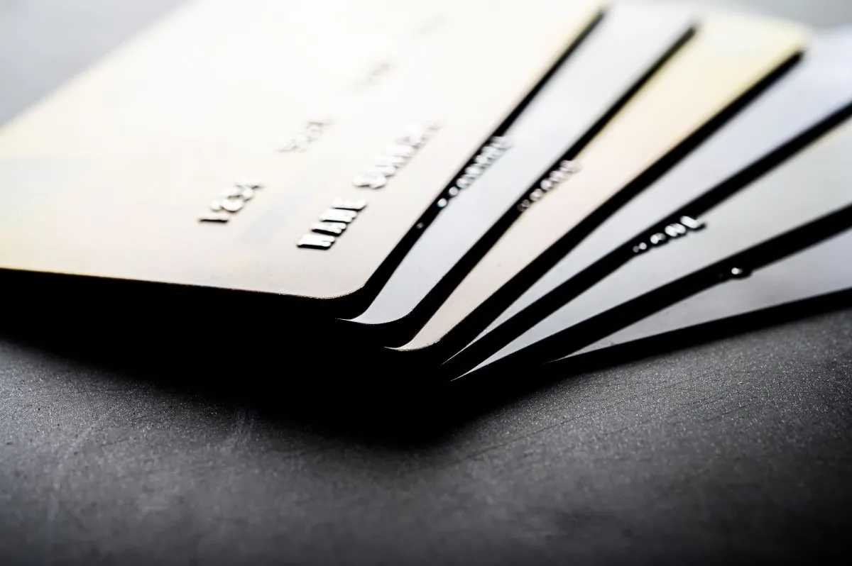 Close-up of multiple credit cards arranged on a dark surface.