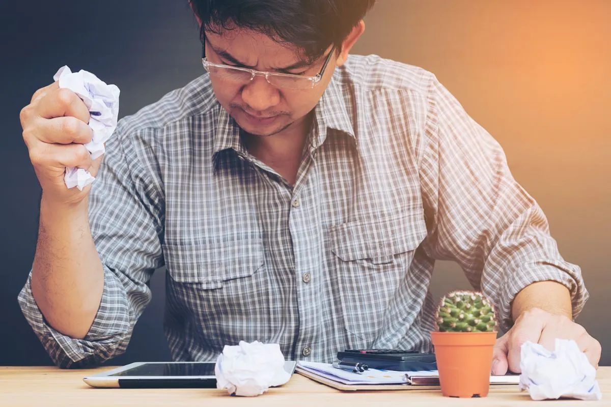 man working seriously with crumpled paper his hand